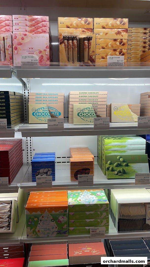 A display of various Royce chocolate bars and boxes on shelves.