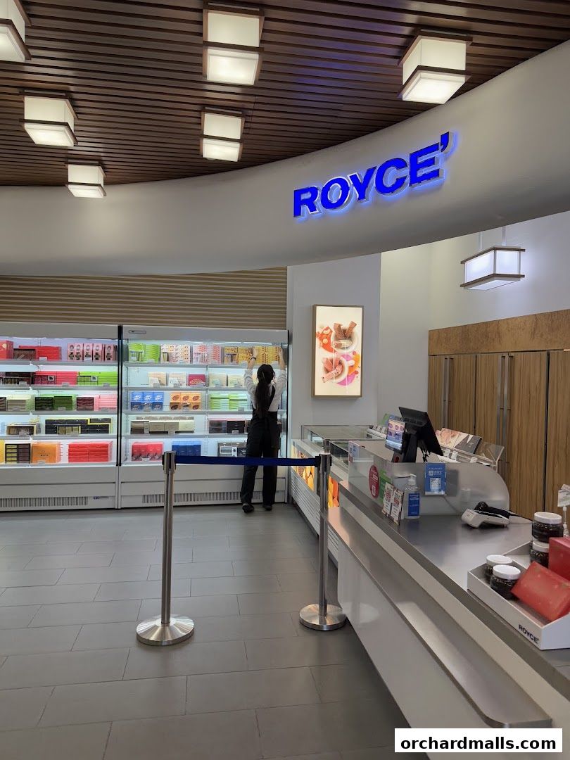 Interior view of a Royce shop with illuminated signage and display cases filled with products.