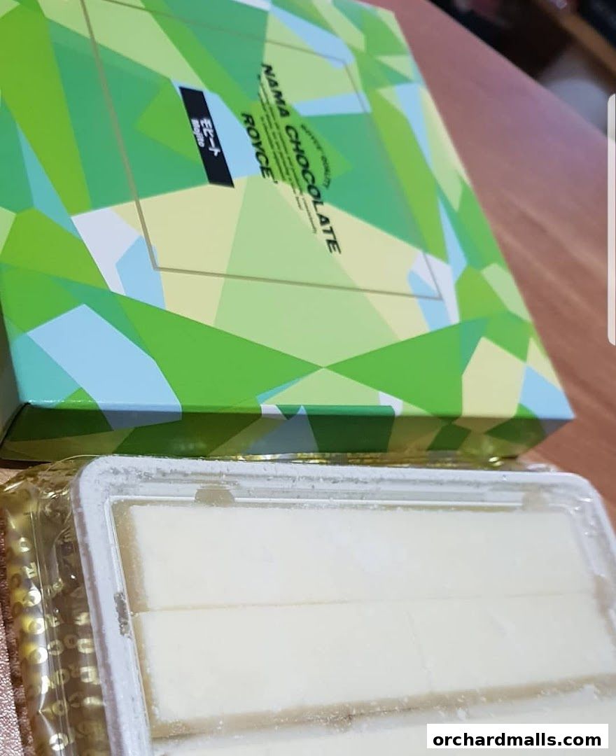A box of Royce Nama Chocolate with a tray of white chocolate pieces.