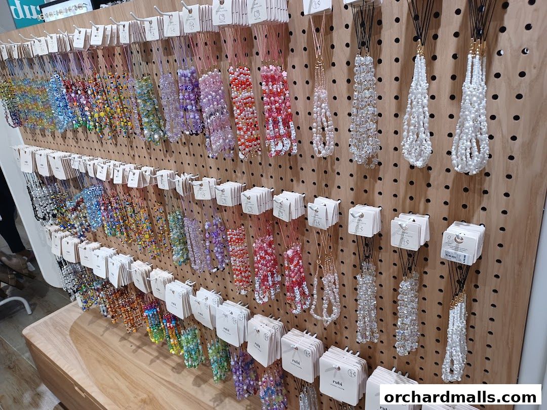 A display wall showcasing a variety of colorful beaded necklaces and charms from Rubi Shoes.