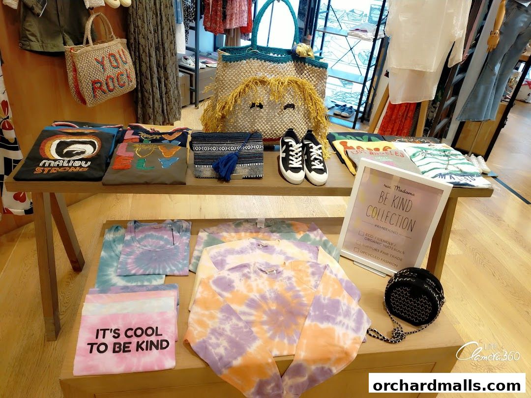 A display of tie-dye apparel, graphic tees, bags, and shoes at Rue Madame.