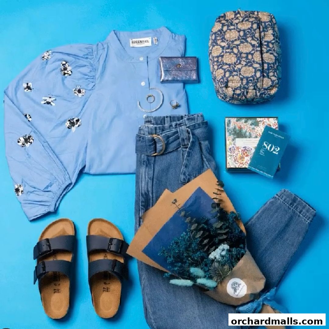 A flat lay of women's clothing and accessories in shades of blue and denim.