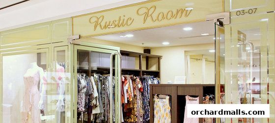 The entrance of Rustic Room boutique, showcasing dresses and apparel on display.