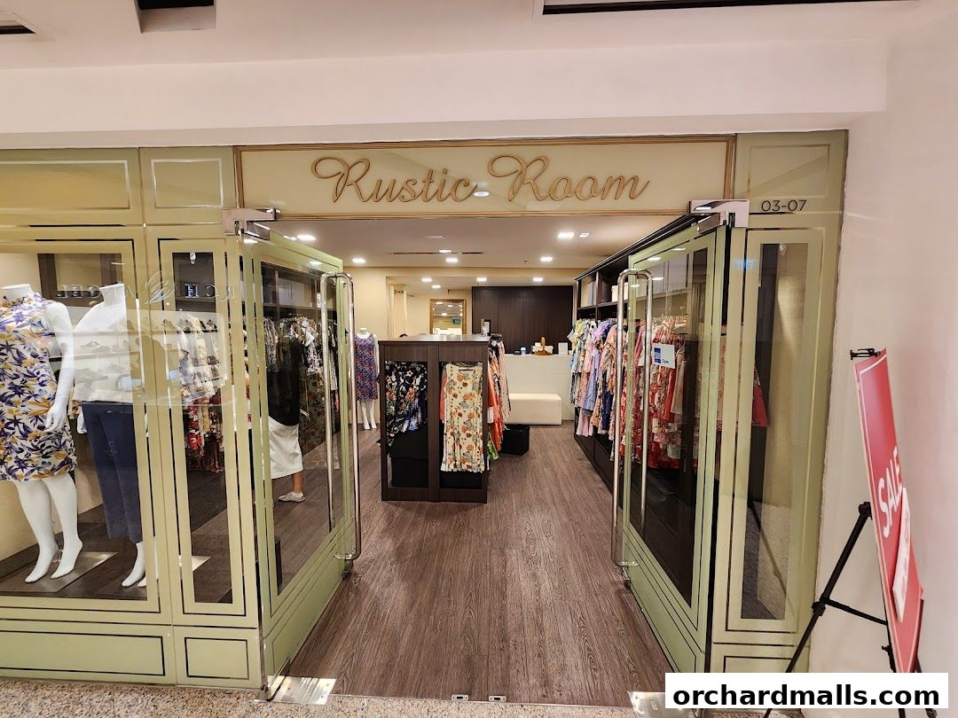 The entrance of a clothing store named Rustic Room, showcasing dresses and mannequins.
