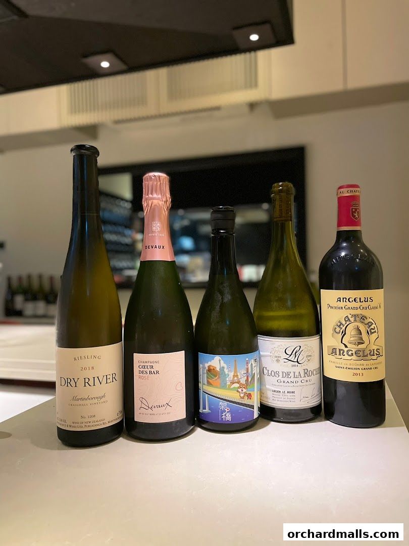 Five bottles of wine and champagne displayed on a counter.