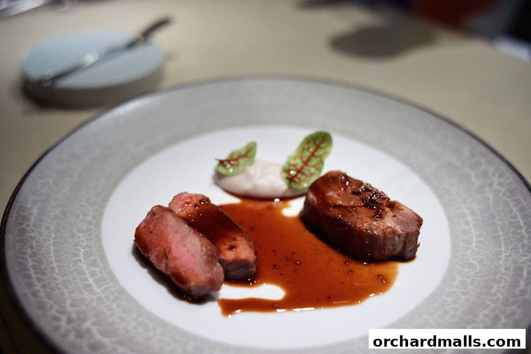 A beautifully plated dish of sliced meat with sauce and garnishes on a textured plate.