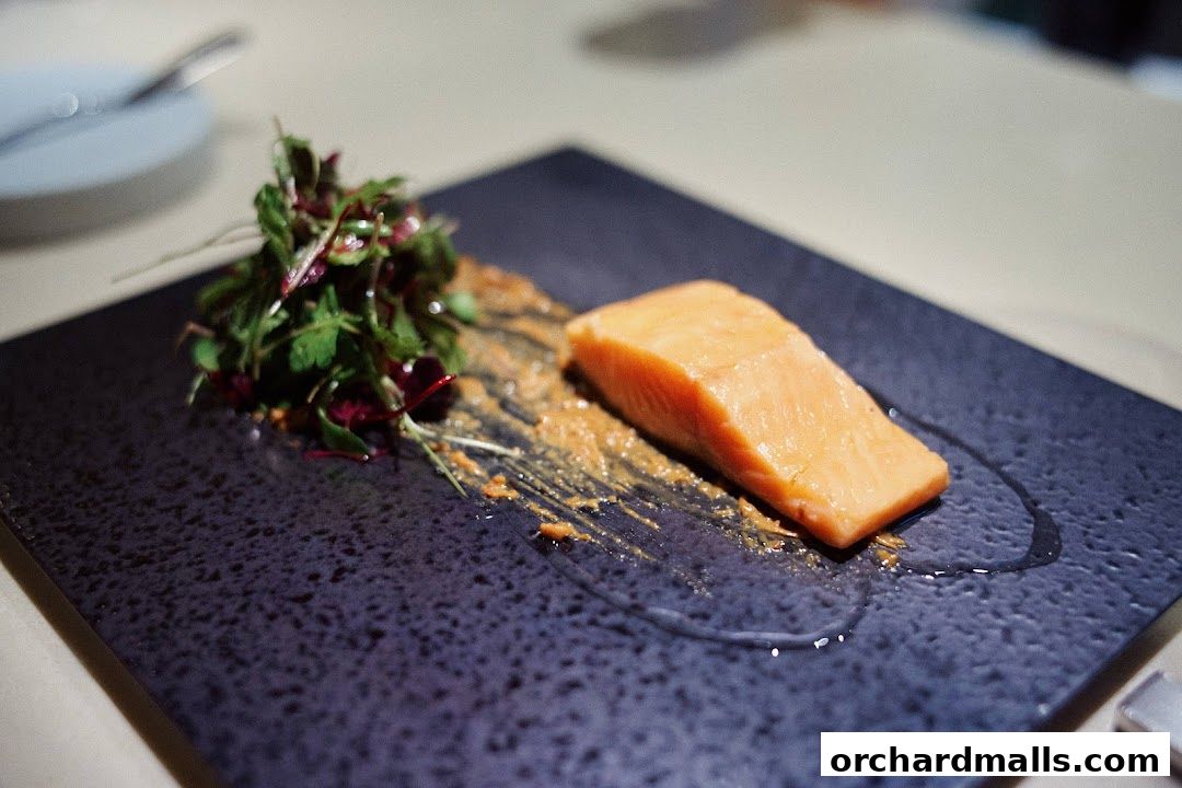 A beautifully plated salmon dish with fresh greens and a savory sauce.