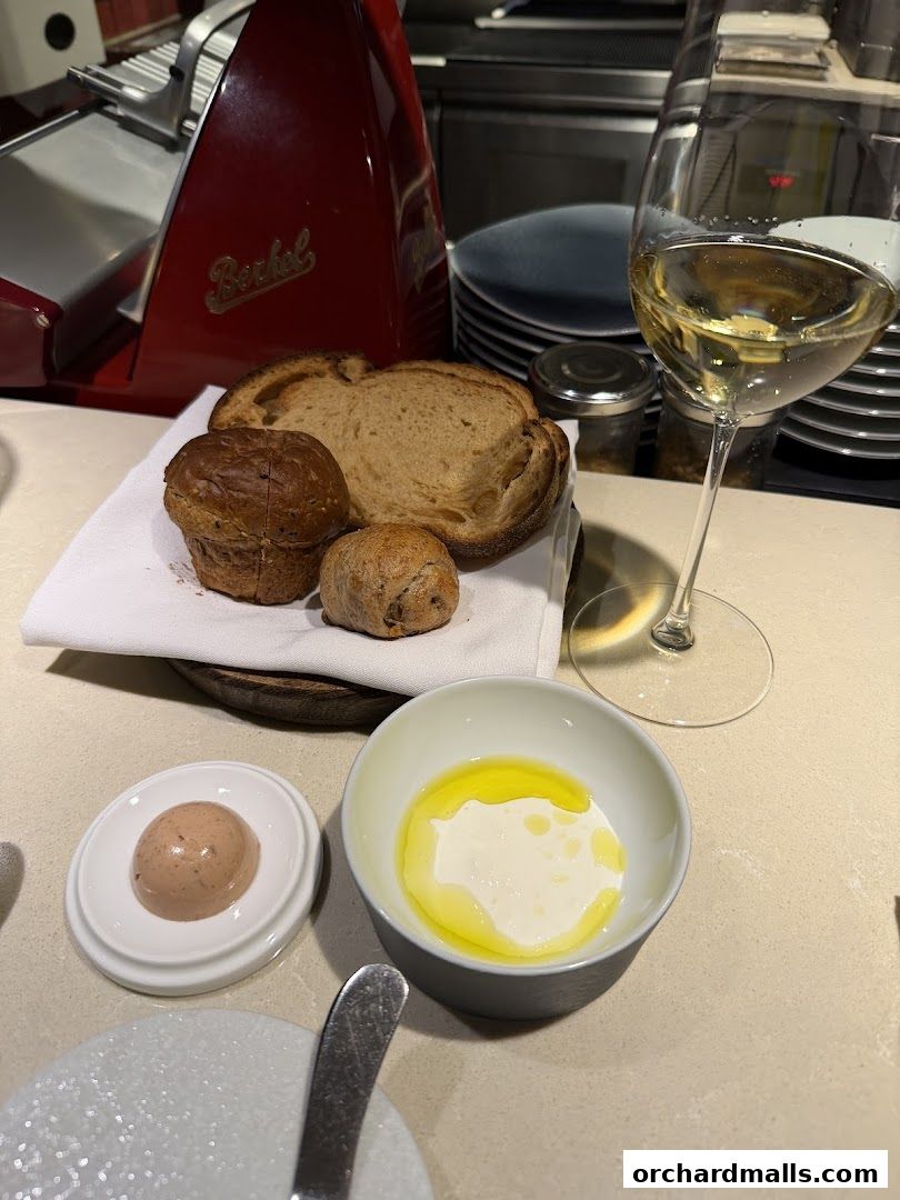 A selection of artisanal breads, pâté, and a glass of white wine.