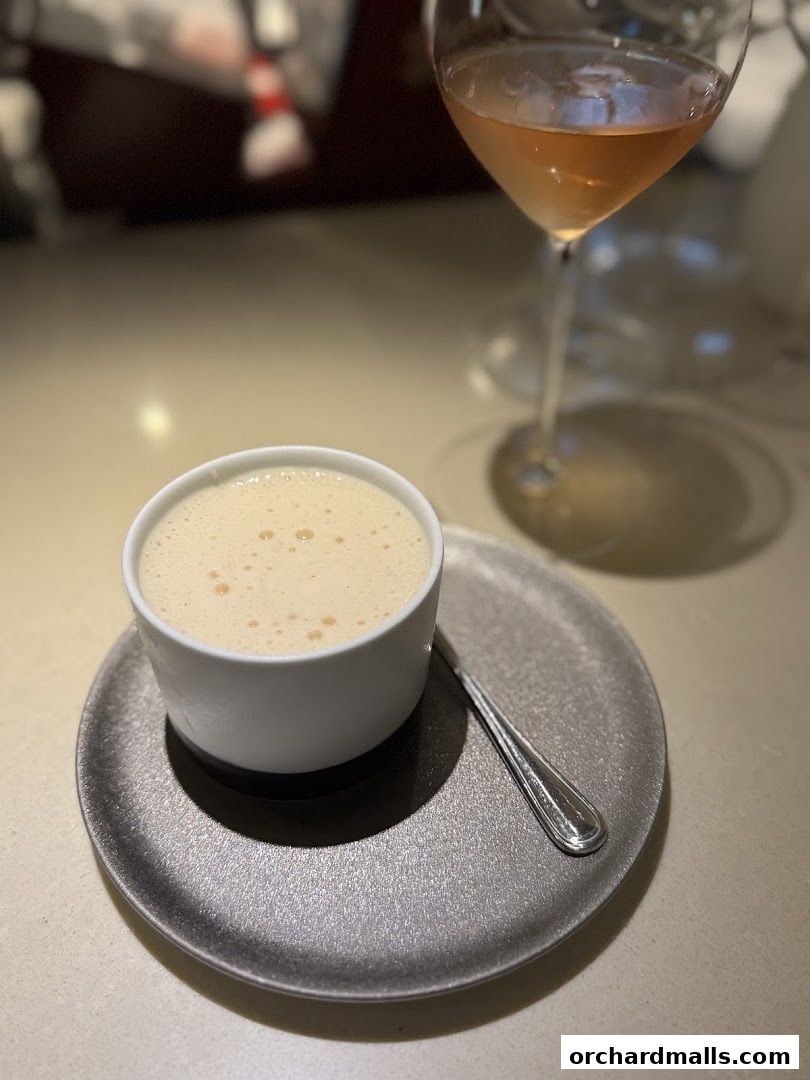 A delicate dessert served in a white ramekin with a glass of rosé wine.