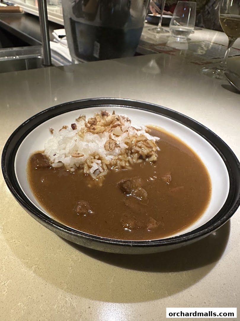 A bowl of Japanese curry with rice and crispy fried onions.