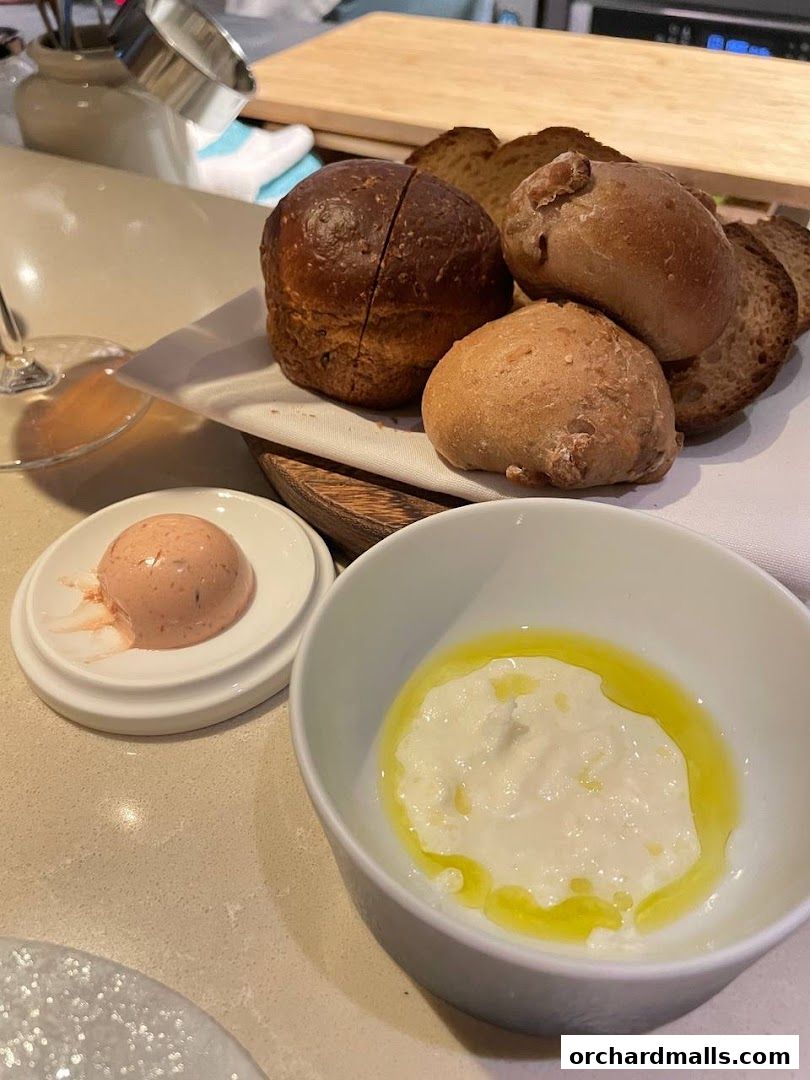 A selection of artisanal breads and dips served at a restaurant.
