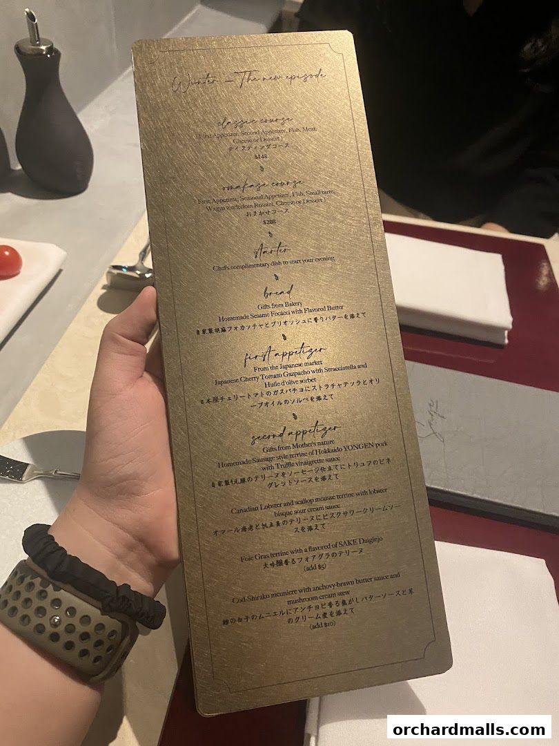 A golden menu from Sage by Yasunori Doi, detailing courses and dishes.