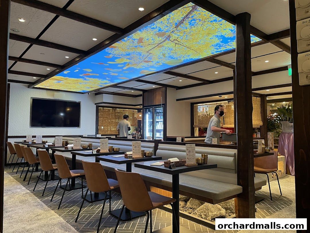 Interior of a Korean restaurant with tables, seating, and a decorative ceiling.