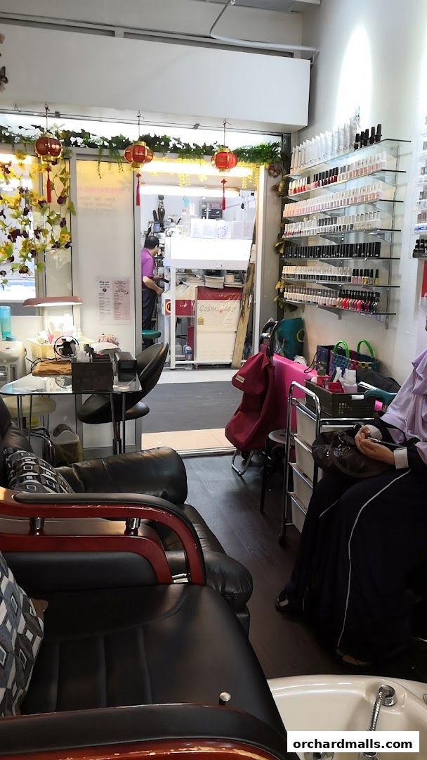 Interior of a nail salon with manicure stations, pedicure chairs, and shelves of nail polish.