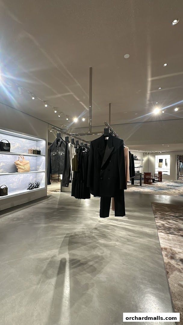 Interior view of a Saint Laurent store showcasing clothing and handbags on display.