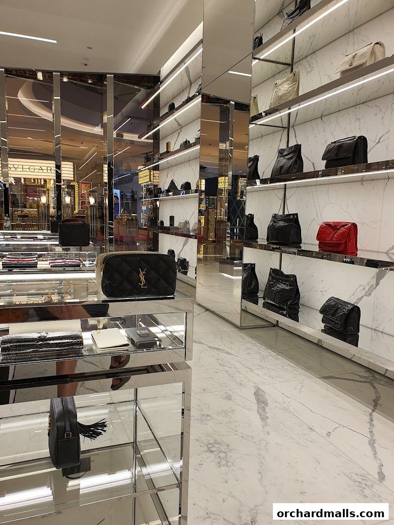 Interior of a Saint Laurent store showcasing handbags and accessories on marble shelves.