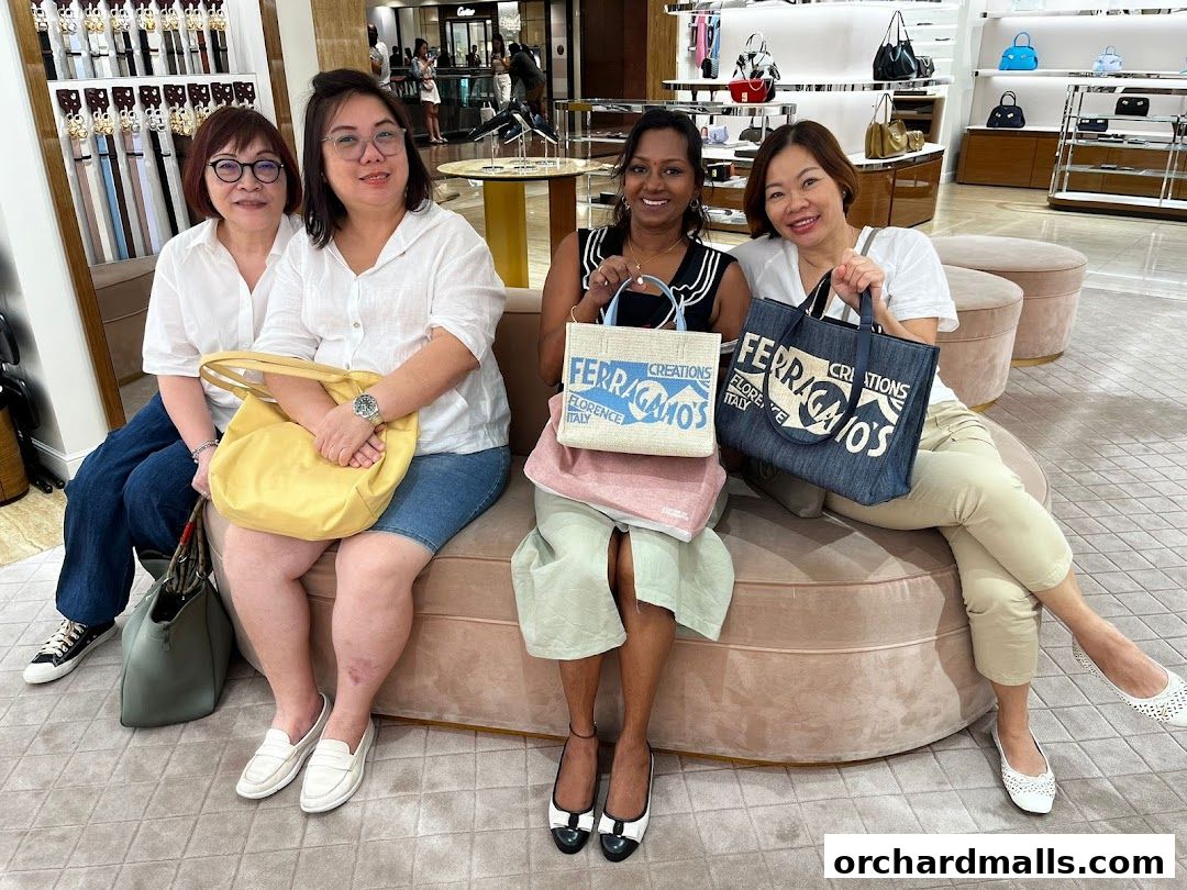 Four women posing with shopping bags inside a Salvatore Ferragamo store.