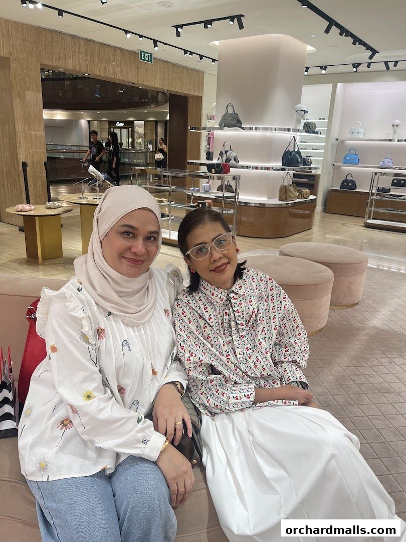 Two women posing for a photo inside a Salvatore Ferragamo store.
