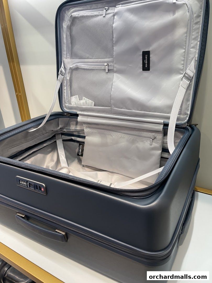 An open Samsonite suitcase showcasing its organized interior with mesh compartments and straps.
