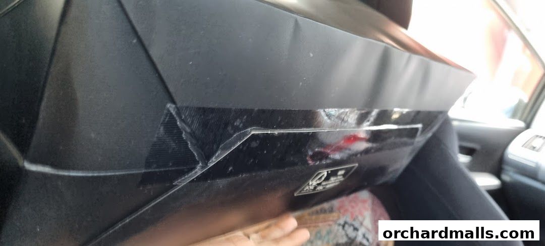 A black Samsonite shopping bag with tape on the corner, inside a car.