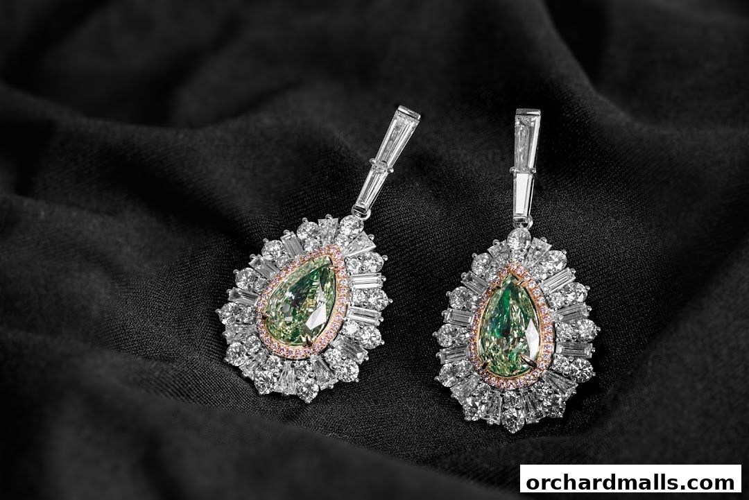 Exquisite pear-shaped green diamond earrings surrounded by white diamonds and pink accents.