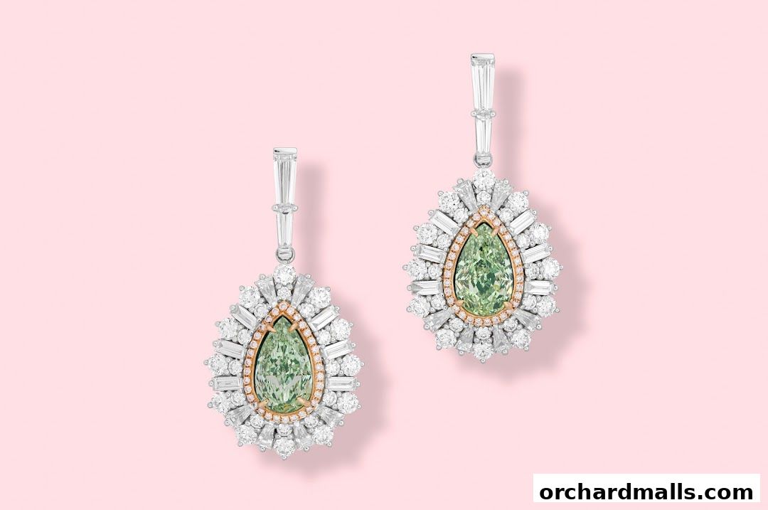 A pair of exquisite pear-shaped green diamond earrings surrounded by white diamonds.