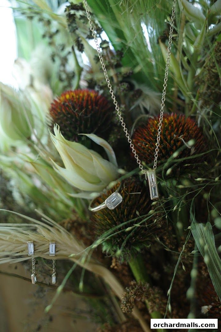 Elegant diamond jewelry set against a backdrop of dried flowers and greenery.