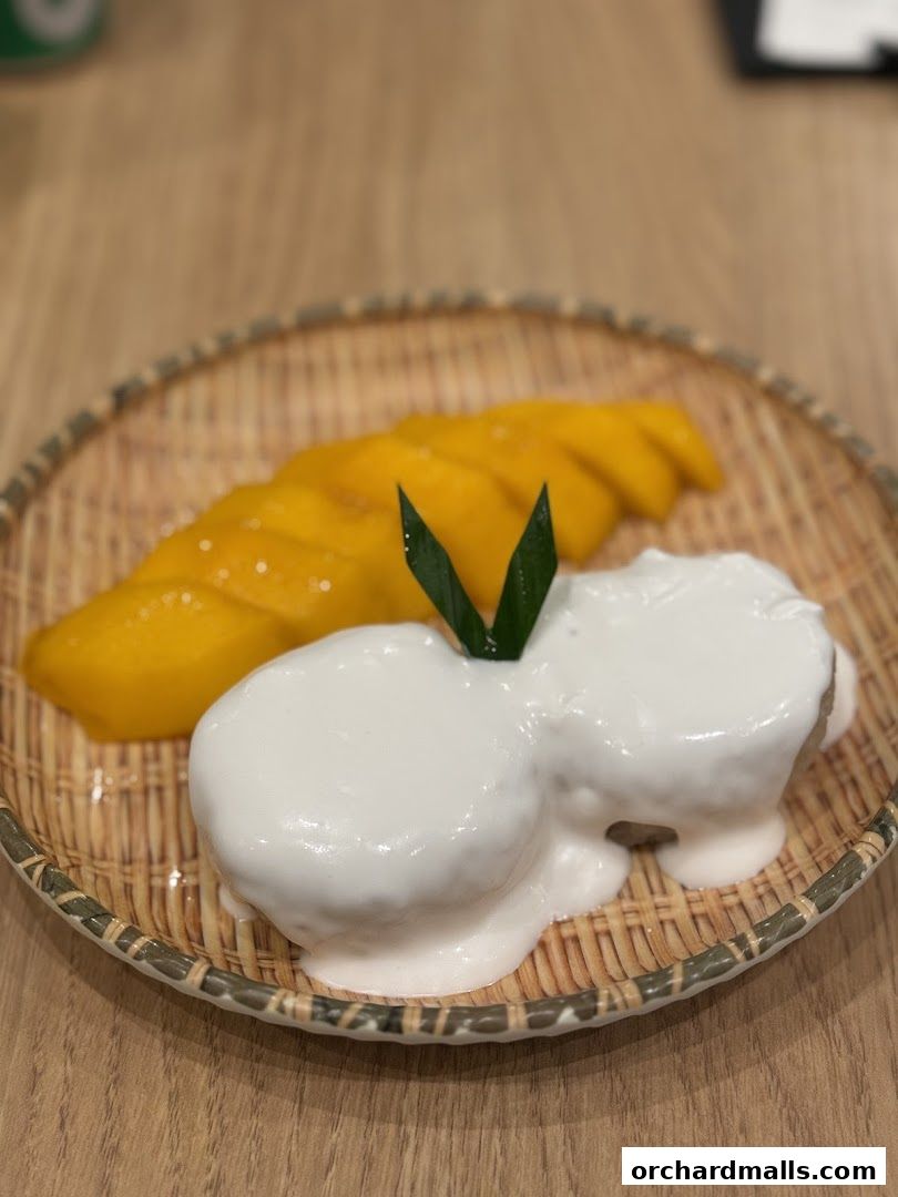 A close-up of mango sticky rice dessert served on a woven plate.