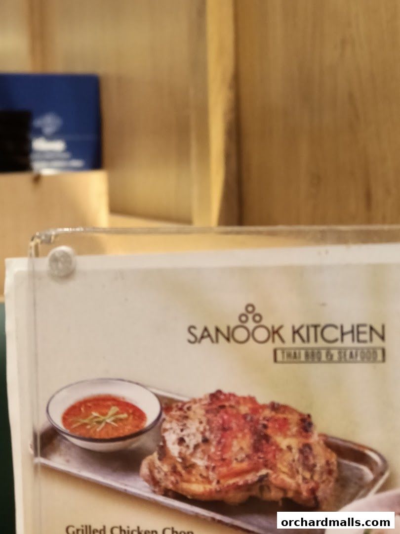 A close-up of a menu item featuring grilled chicken chop with dipping sauce.