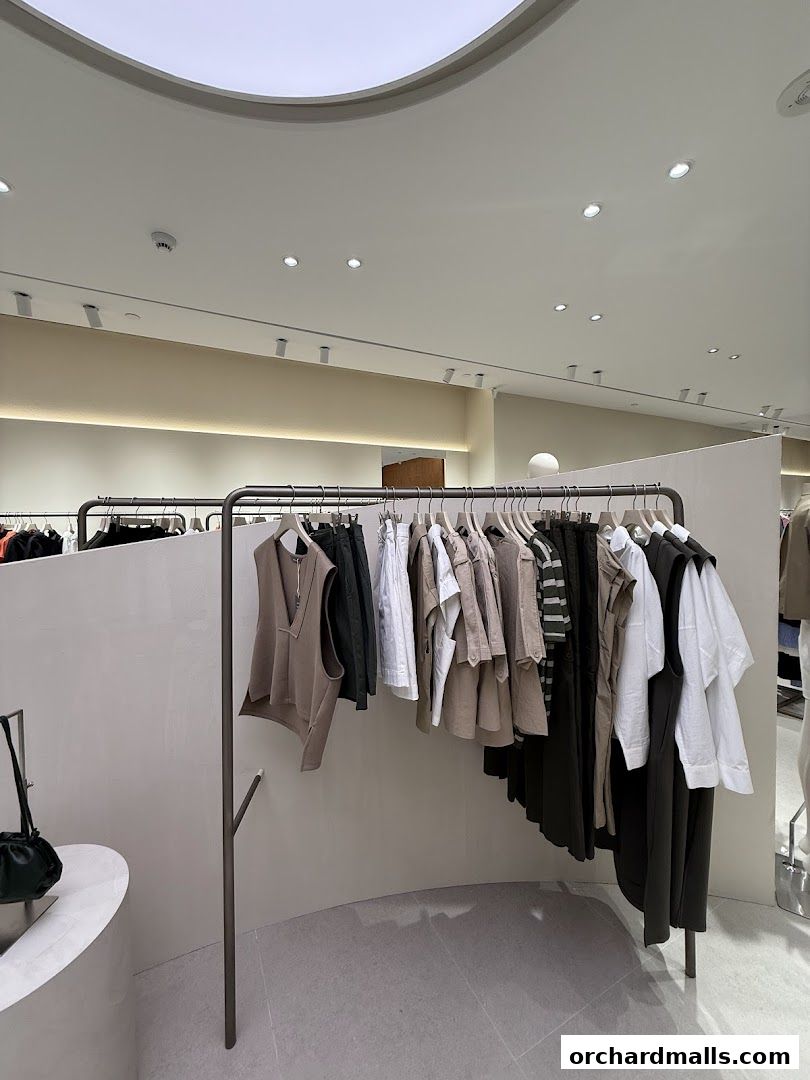 A curated selection of minimalist women's clothing displayed on a curved rack.