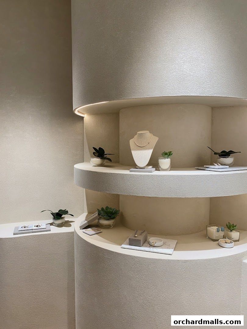 Elegant display of jewelry and decorative items on curved shelves with soft lighting.