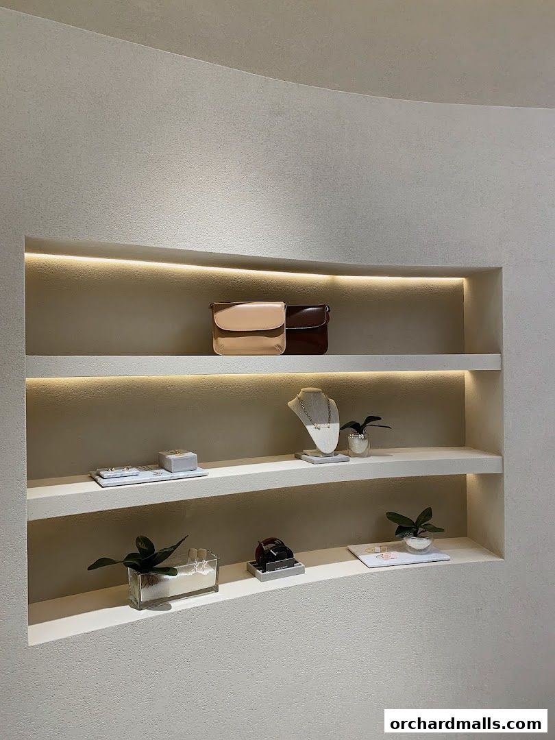 A retail display showcasing handbags, jewelry, and watches on illuminated shelves.