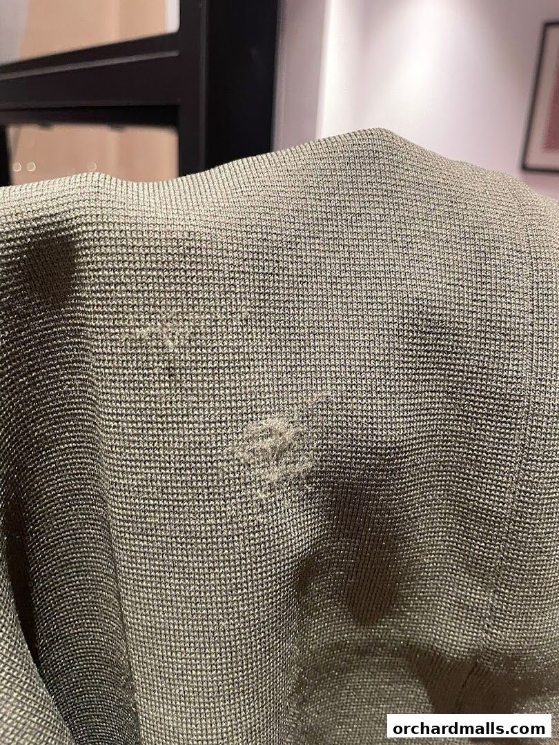 Close-up of a damaged textured fabric, possibly a garment.