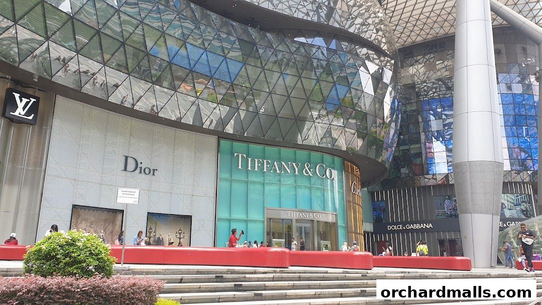 Exterior view of luxury brand stores including Louis Vuitton, Dior, Tiffany & Co., and Dolce & Gabbana.
