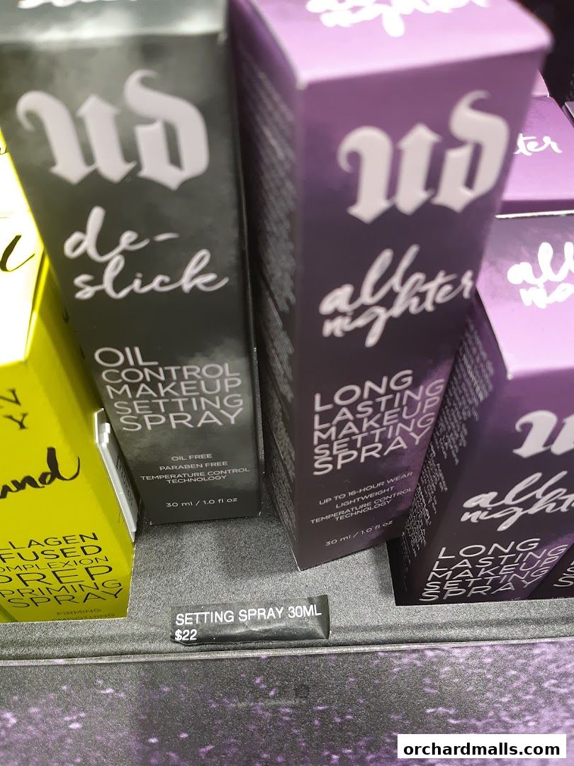 Close-up of Urban Decay setting sprays, including De-Slick and All Nighter variants.