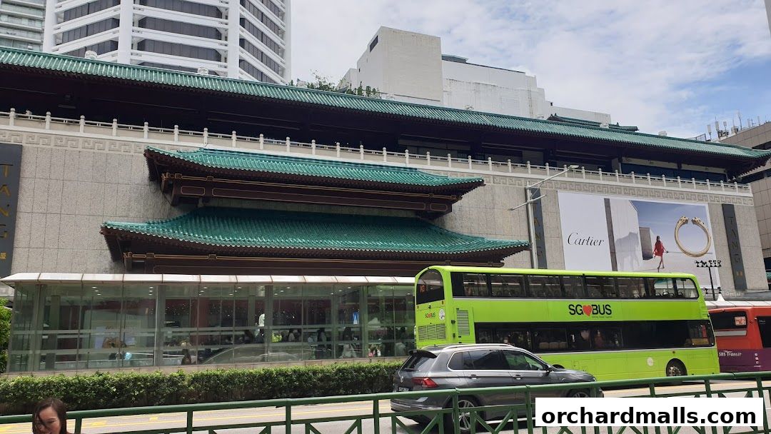 Exterior view of a building with traditional green roofs and a large Cartier advertisement.