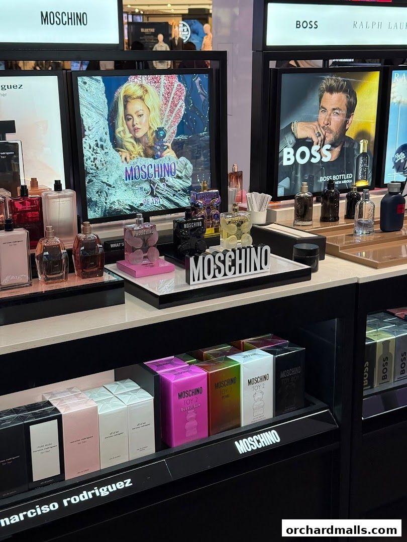 A display of Moschino and Narciso Rodriguez perfumes with advertising screens.