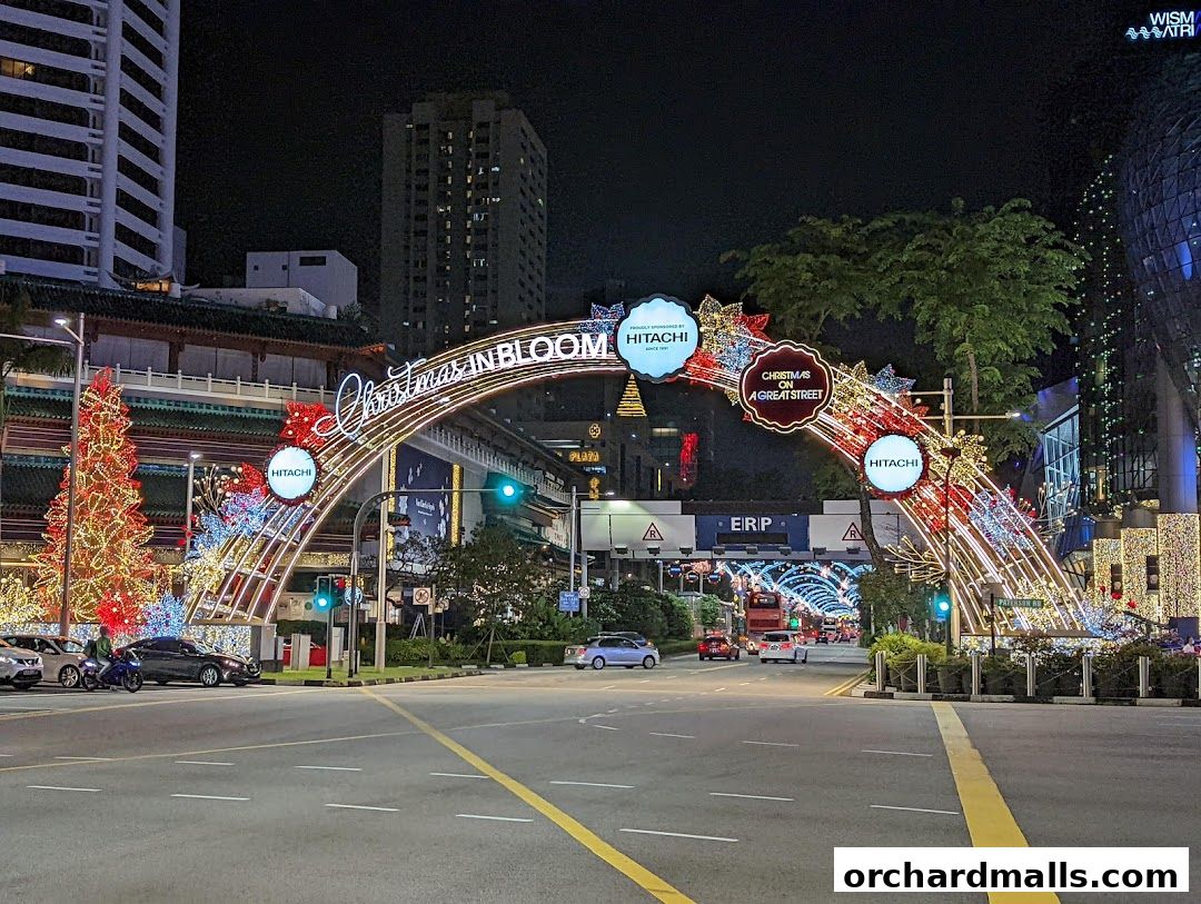 A street decorated with Christmas lights and a large archway, sponsored by Hitachi.