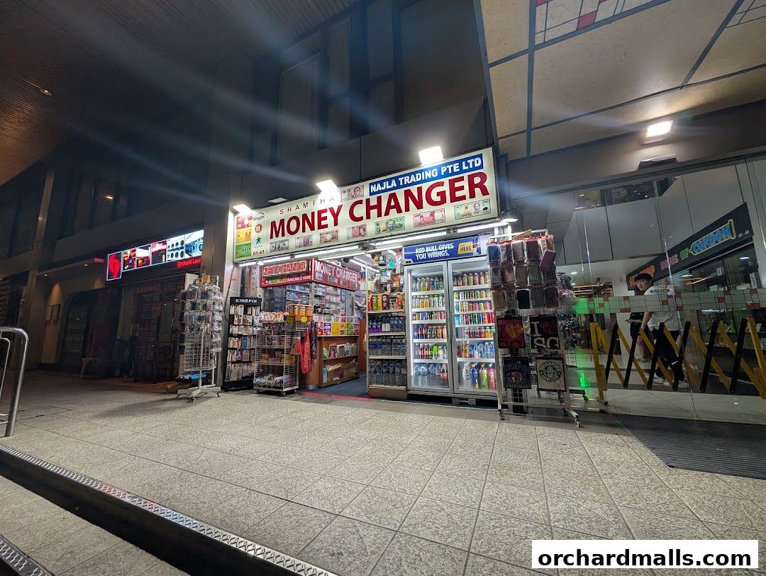 Exterior of Shamiha Money Changer shop with currency exchange services and various goods displayed.