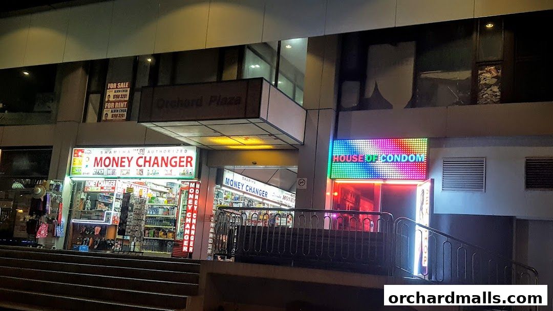 Exterior view of Shamiha Money Changer and House of Condom shops at night.