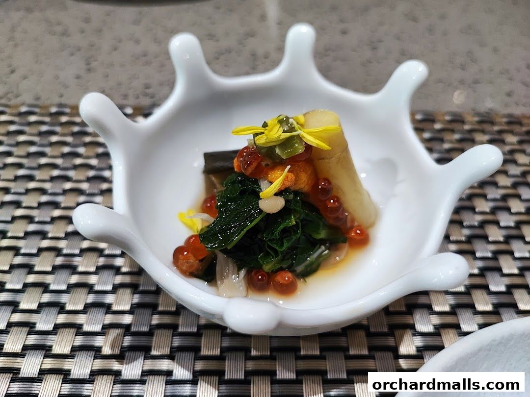 A close-up of a small, artfully presented Okinawan dish in a unique white bowl.