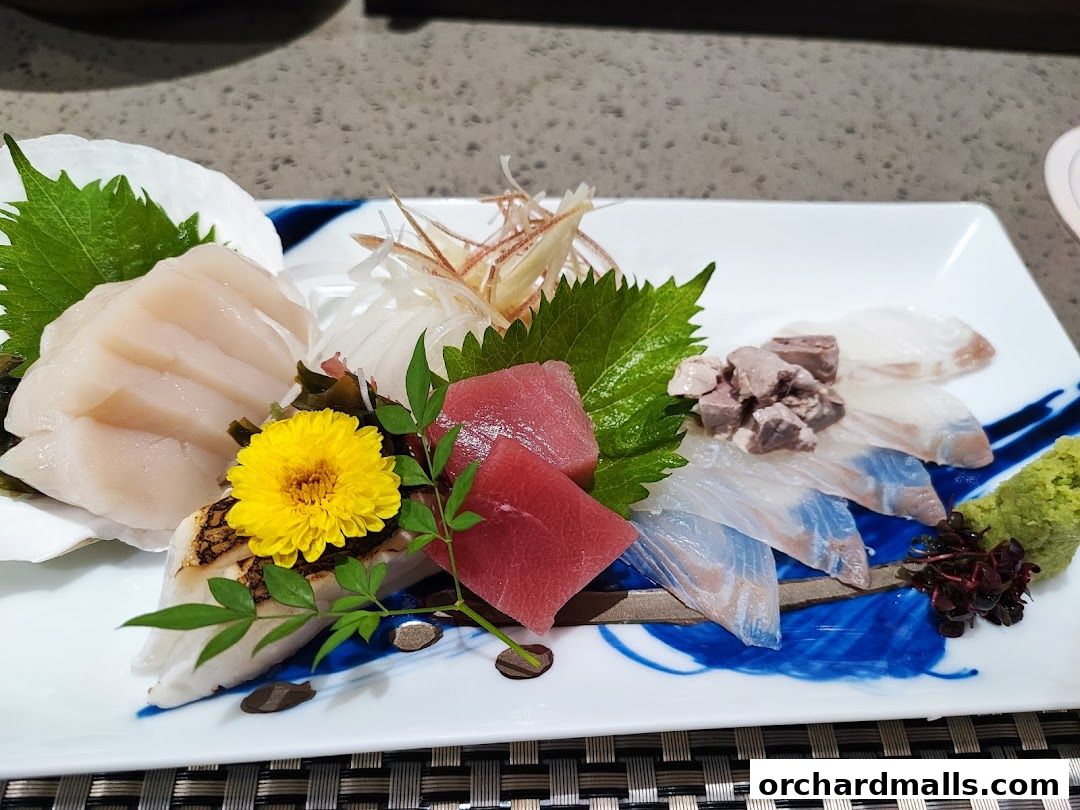 A platter of fresh sashimi, including tuna, scallops, and white fish, beautifully garnished.