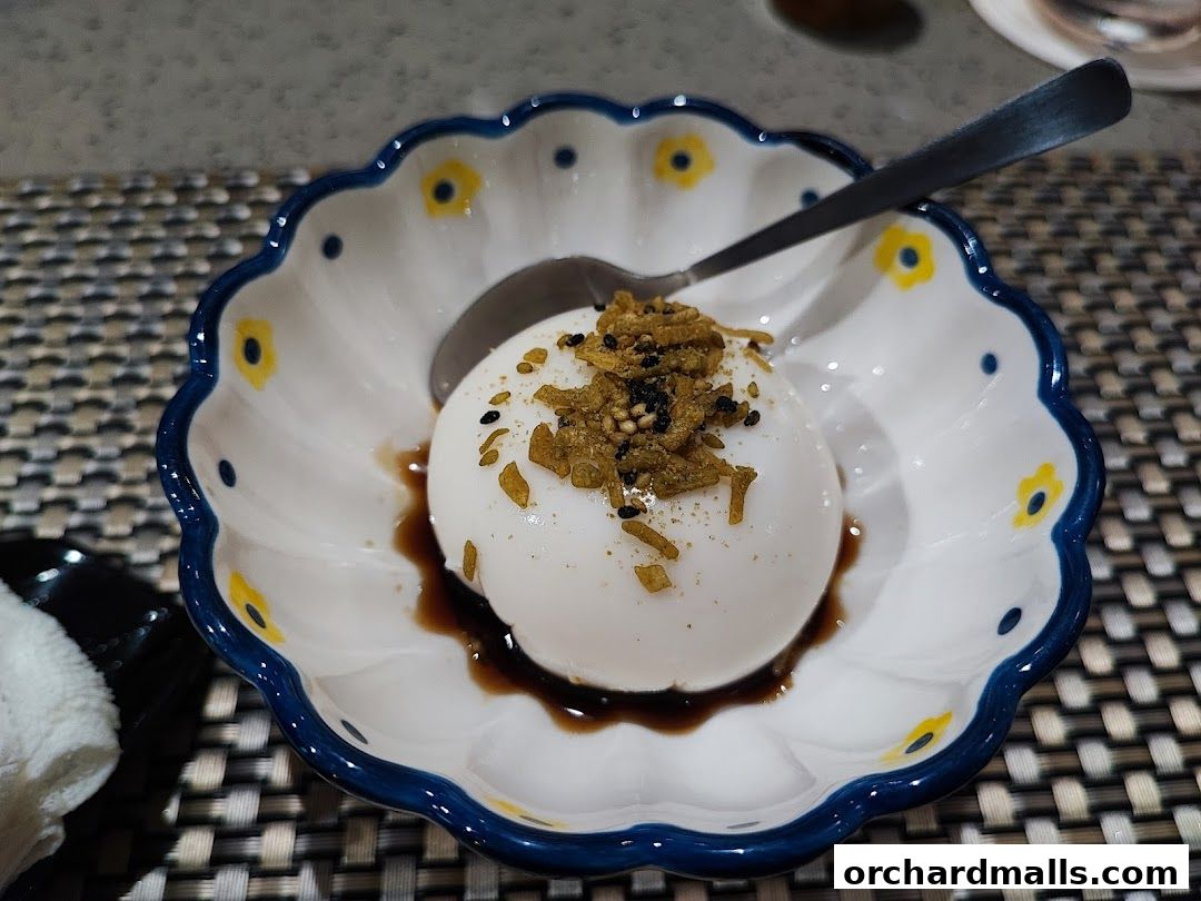 A delicate dessert served in a decorative bowl with a spoon.