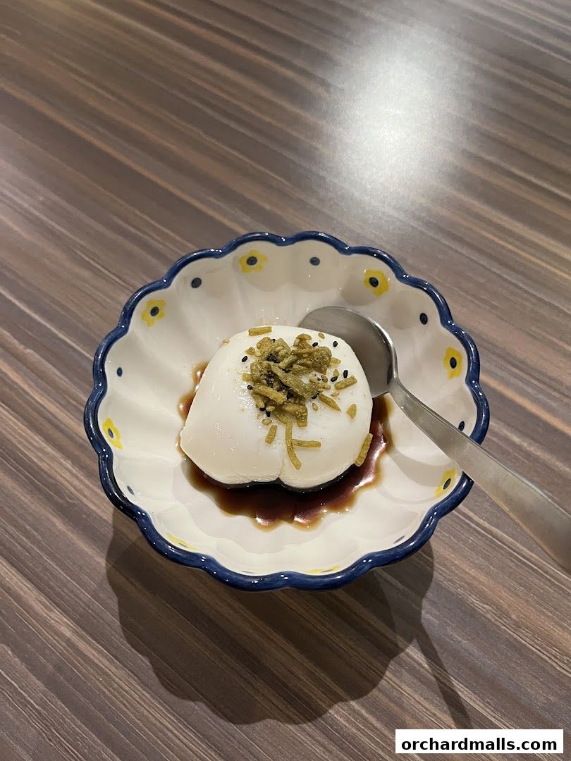 A delicate dessert served in a decorative bowl with a spoon.