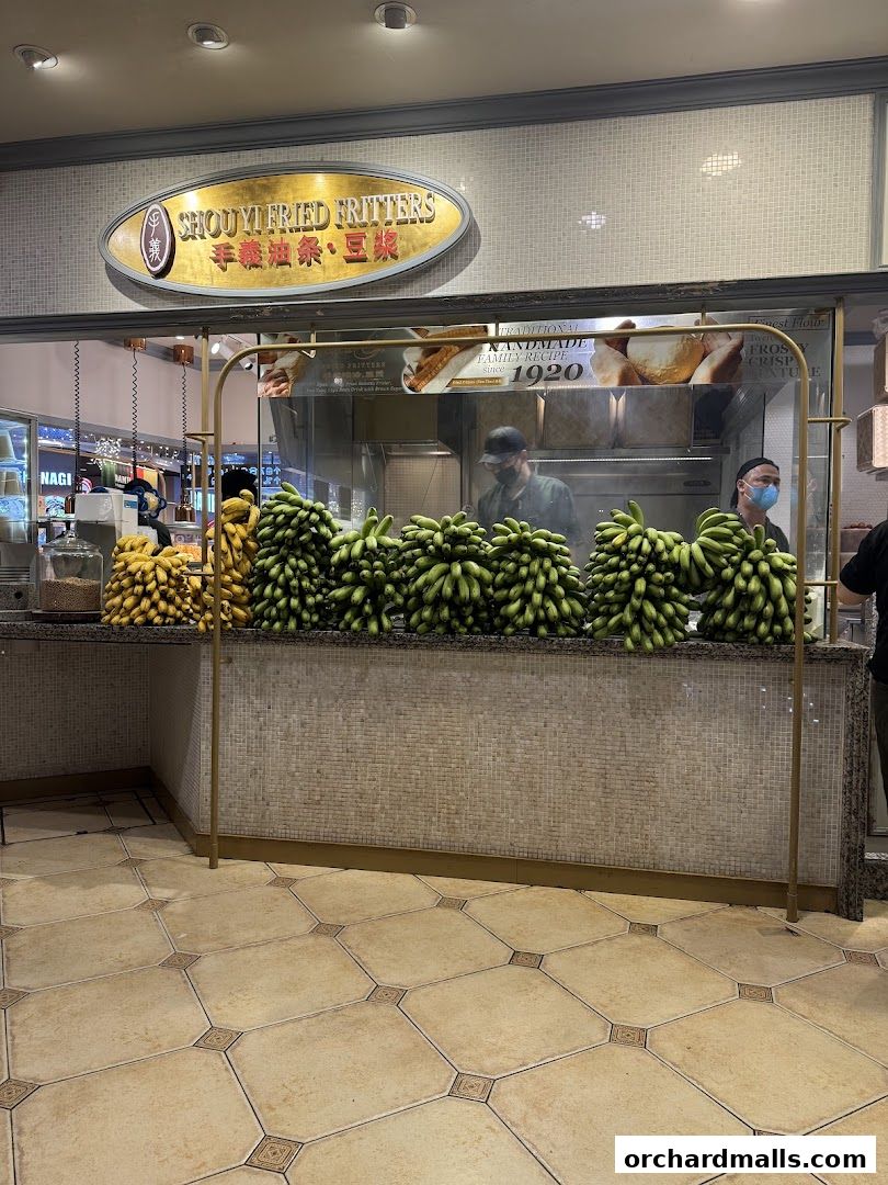 Shou Yi Fried Fritters shop front with fresh bananas and staff preparing food.