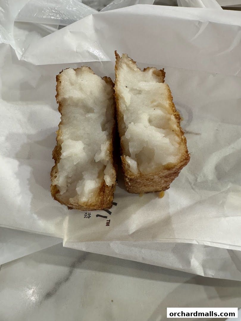 Two pieces of fried fritters, cut in half, revealing a fluffy white interior.