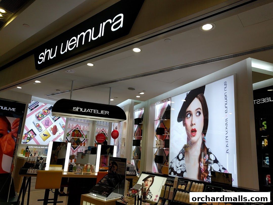 Interior view of a Shu Uemura cosmetics store with product displays and advertising.