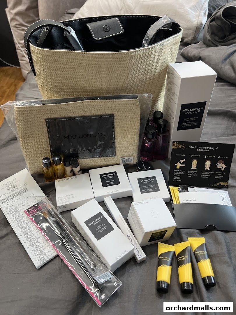 A collection of Shu Uemura beauty products, including makeup, skincare, and accessories, laid out on a surface.
