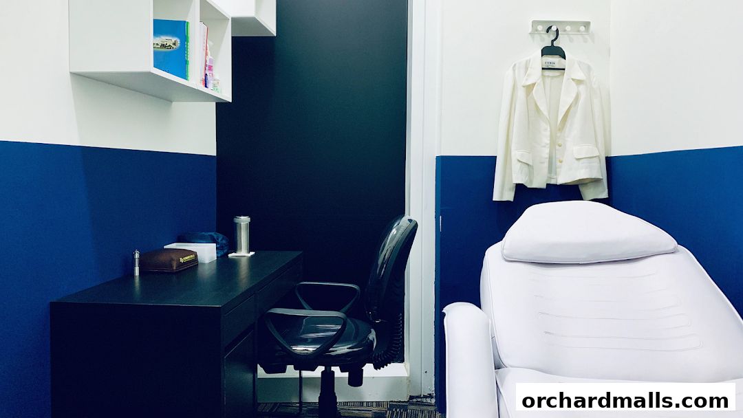 Interior view of a clinic room with a treatment chair, desk, and jacket.