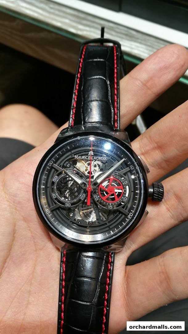 A close-up shot of a Maurice Lacroix watch with a black alligator strap and red stitching.